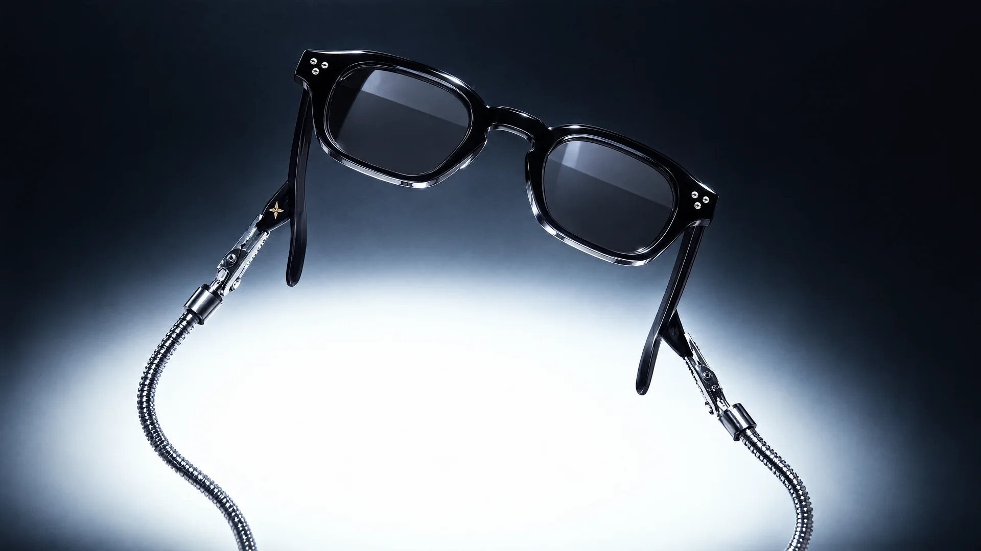 Black Nano frame held up by two metal clamps under a soft spotlight